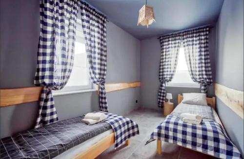 dwa łóżka w pokoju z dwoma oknami w obiekcie Apartamenty Koniaków Residence w mieście Koniaków
