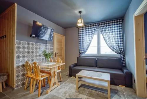 salon z kanapą, stołem i krzesłami w obiekcie Apartamenty Koniaków Residence w mieście Koniaków