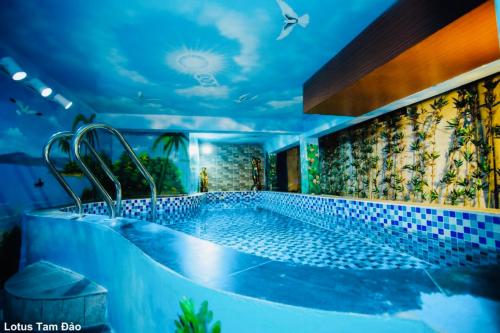 a bathroom with a large tub with blue tiles at Lotus Tam Đảo Hotel in Tam Ðảo