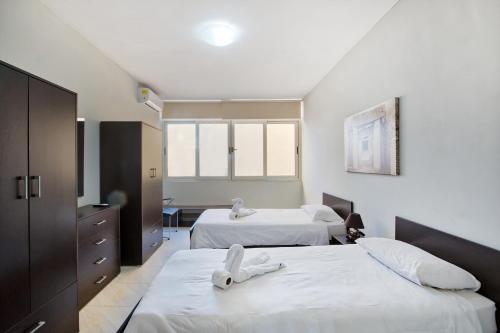 a bedroom with two beds with white sheets at Spacious Seafront 3BR, Sliema near Beach, AC Wifi by 360 Estates in Sliema