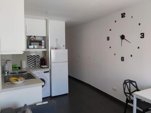 a kitchen with a refrigerator and a clock on the wall at Apartamento Turismo Badajoz in Badajoz
