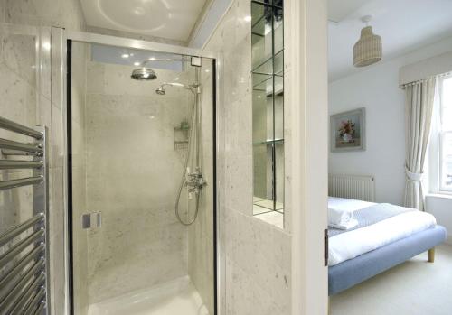 uma casa de banho com um chuveiro e uma porta de vidro em Dolls House - Luxury Townhouse *sleeps 10* em Henley on Thames