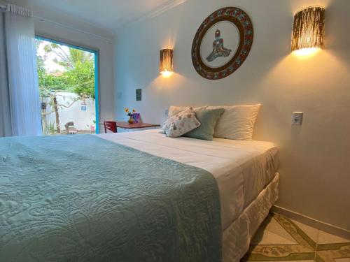 sypialnia z dużym łóżkiem i oknem w obiekcie Pousada Canto de Paz w mieście Porto Seguro