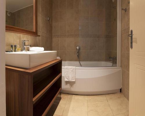 La salle de bains est pourvue d'un lavabo et d'une baignoire. dans l'établissement Les TERRASSES D'ISOLA 2000, à Isola