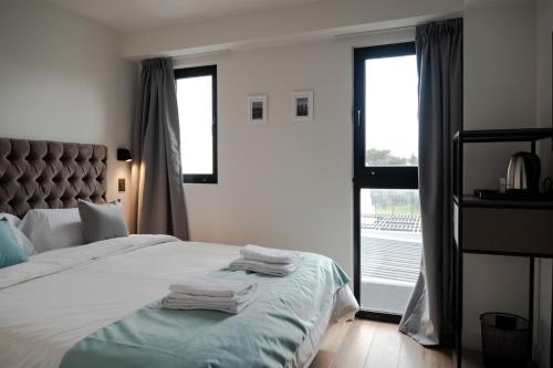a bedroom with a bed with towels on it at Arena Suites in Mar del Plata
