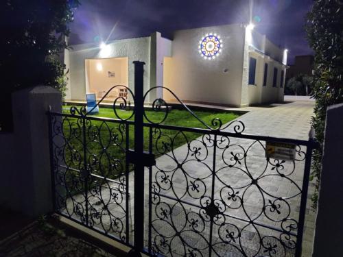 a gate in front of a house at night at Pool Seaside Relais - VILLE Ninfea, Marea, Rosa e Cassiopea in Fontane Bianche