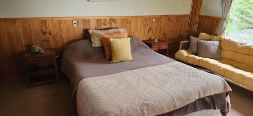- une chambre avec un lit et des oreillers dans l'établissement Cabaña para 5 personas, Villarrica-Pucón con vista privilegiada ., à Villarrica
