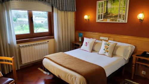 um quarto de hotel com uma cama e uma janela em Hotel A Marisqueira I Aeropuerto A Coruña em Oleiros