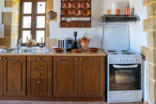 a kitchen with a stove and a sink at IOANNIS STONEHOUSE, Quiet, Privacy & Sea View. in Kissamos