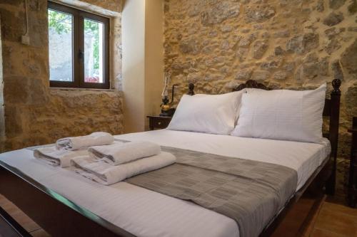 a bedroom with a bed with towels on it at IOANNIS STONEHOUSE, Quiet, Privacy & Sea View. in Kissamos