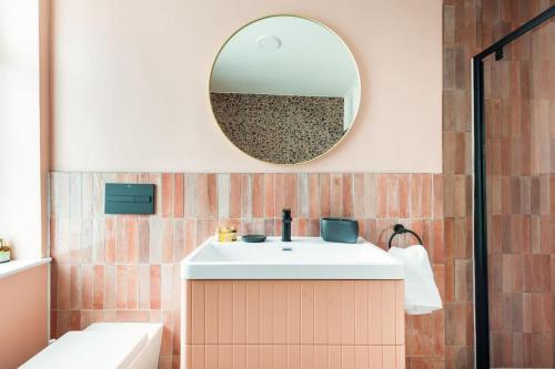 a bathroom with a sink and a mirror at Penarth Townhouse close to Cardiff & Bay in Cardiff