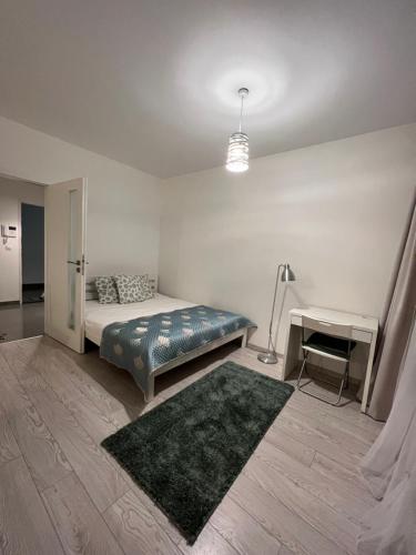 Schlafzimmer mit einem Bett, einem Tisch und einem Teppich in der Unterkunft FREE PARKING in garage! New apartment in Karolina Plazza in Prag