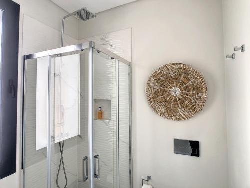 a bathroom with a shower and a clock on the wall at Noah - Private Sunset Hideaway by LovelyStay in Arco da Calheta