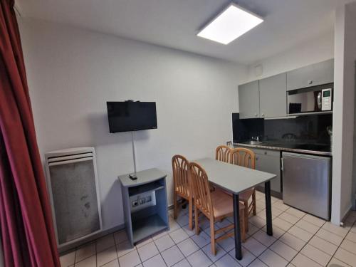 eine Küche mit einem Tisch und Stühlen im Zimmer in der Unterkunft Bulle enchantée entre lac et montagne in Allevard