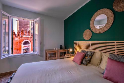 una camera da letto con un grande letto con una parete verde di Mahamo Suites a Verona