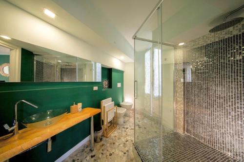 uma casa de banho com um lavatório e uma cabina de duche em vidro. em Mahamo Suites em Verona
