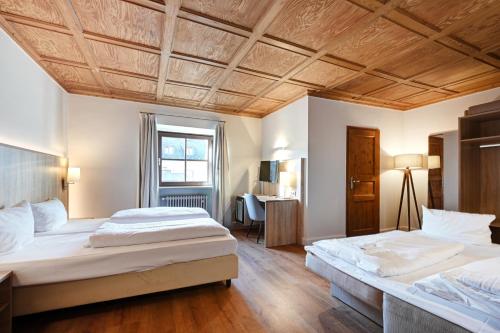 2 Betten in einem Schlafzimmer mit Holzdecke in der Unterkunft Hotel Schleuse in München