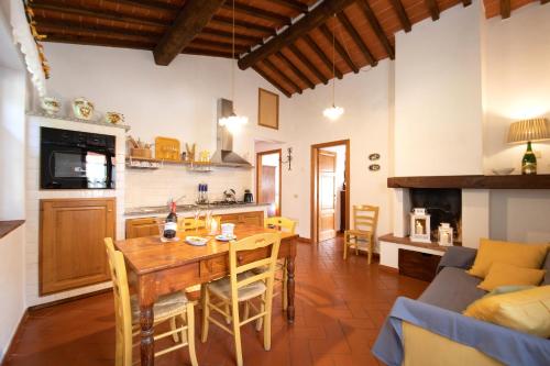 a kitchen and living room with a wooden table and chairs at Casetta di Butia, Gelsomino Apartment in Borgo a Mozzano