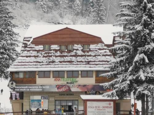 a large building with snow on the roof at Cabana Fantanita cu Brazi in Poiana Brasov