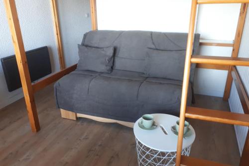 un salon avec un canapé et une table dans l'établissement Studio 2-3 pers at the foot of the slopes, à Mâcot La Plagne