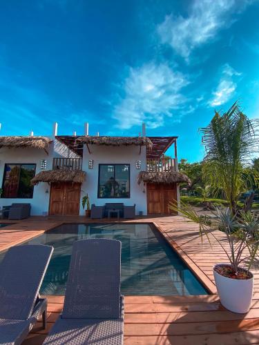 a villa with a swimming pool and a house at Hotel Maya Jade in Monterrico