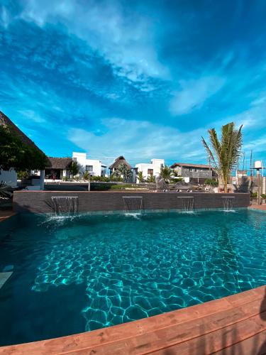 a swimming pool with blue water in a resort at Hotel Maya Jade in Monterrico