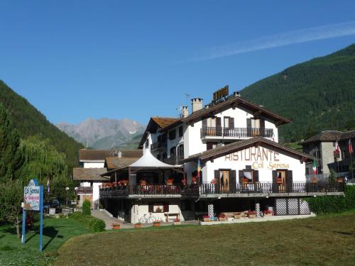 ein großes weißes Gebäude mit einem Balkon auf einem Berg in der Unterkunft Hotel Col Serena in Etroubles