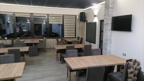 a restaurant with wooden tables and chairs and a tv at Planinska Kraljica in Gornje Pale