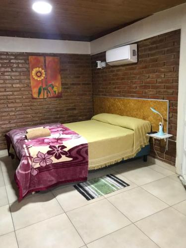 1 dormitorio con 2 camas en una pared de ladrillo en Hospedaje “Las Lias” en Malargüe