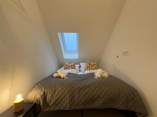 a small bedroom with a bed with a window at Moderne Wohnung mit Küche & Parkplatz Ausblick auf den bayerischen Wald in Stephansposching