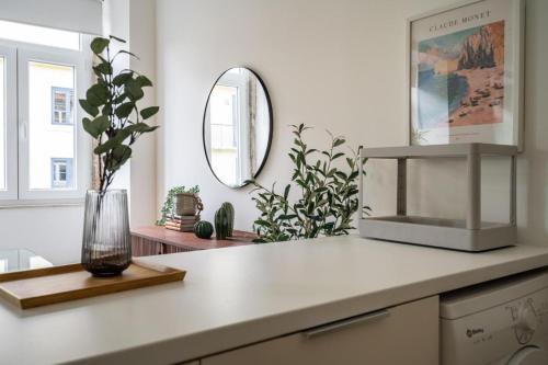 a kitchen counter with a vase and a mirror at WHome Chic 2-Bed near Santos & Alcântara perfect for Families & Couples in Lisbon