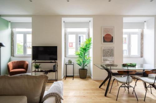 a living room with a tv and a table and chairs at WHome Chic 2-Bed near Santos & Alcântara perfect for Families & Couples in Lisbon