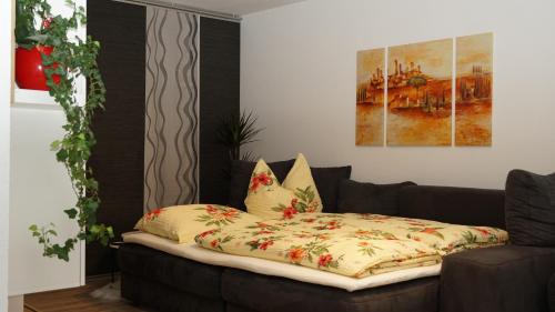 ein Sofa mit einer Decke darauf im Wohnzimmer in der Unterkunft Gemütliches Apartment in Bad Berneck in Bad Berneck im Fichtelgebirge