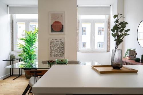 a dining room with a white table and some plants at WHome Chic 2-Bed near Santos & Alcântara perfect for Families & Couples in Lisbon