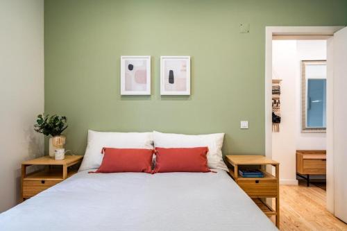 Schlafzimmer mit einem weißen Bett und roten Kissen in der Unterkunft WHome Chic 2-Bed near Santos & Alcântara perfect for Families & Couples in Lissabon