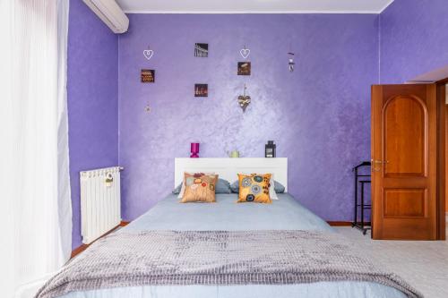 een paarse slaapkamer met een groot bed met paarse muren bij Hostly - Domus Happya - Dream in the Appia Antica Park in Rome