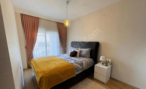 1 dormitorio con 1 cama con manta amarilla y ventana en High Life, en Küçük Çığlı