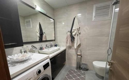 W łazience znajduje się umywalka, toaleta i lustro. w obiekcie High Life 