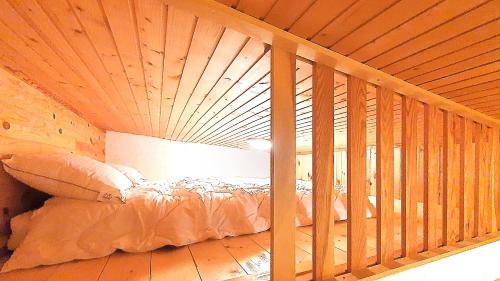 een bed in een kamer met een houten plafond bij La Tanière : 4 personnes in Gérardmer