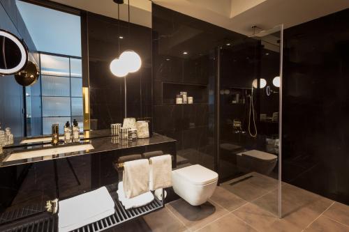 a black bathroom with a toilet and a shower at The Mill Bomonti in Istanbul