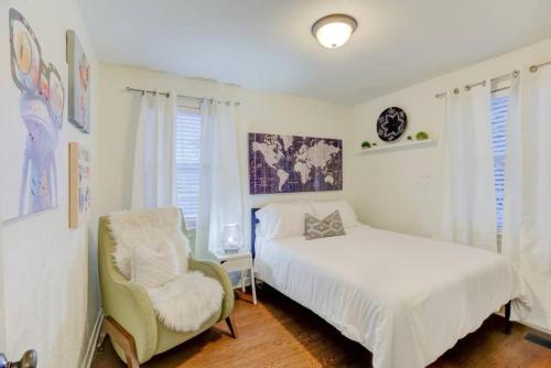 um quarto com uma cama, uma cadeira e uma janela em Private Gated Cottage Walk to Overton Square em Memphis