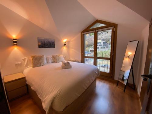 a bedroom with a large white bed and a window at Vitivola Els Esquiadors de Llorts in Llorts