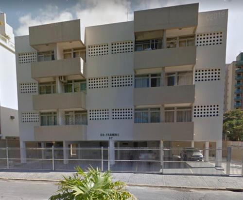 un edificio alto con un coche aparcado delante de él en Apartamento Ótima Localização no Guarujá-Astúrias, en Guarujá