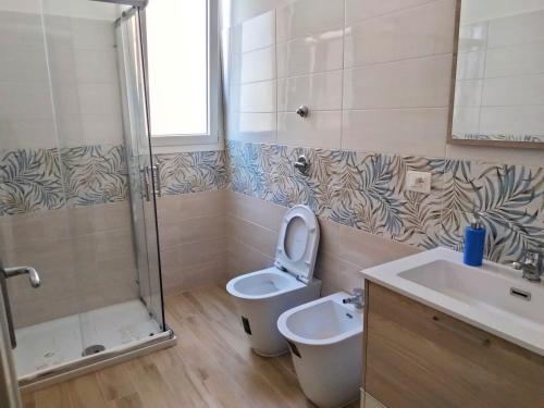 uma casa de banho com um WC, um lavatório e um chuveiro em Kenzia Apartment em Trapani