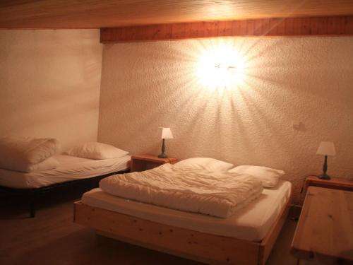 a bedroom with two beds and a light on the wall at Appartement Châtel, 2 pièces, 6 personnes - FR-1-200-211 in Châtel