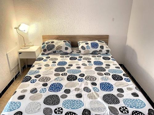 1 cama con almohadas y mantas azules y blancas en Studio Balaruc-les-Bains, 1 pièce, 4 personnes - FR-1-503-25, en Balaruc-les-Bains