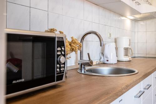 a kitchen counter with a microwave and a sink at Apartment Vesna in Milna