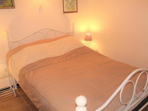 een slaapkamer met een bed met een oranje deken bij Studio Balaruc-les-Bains, 1 pièce, 4 personnes - FR-1-503-51 in Balaruc-les-Bains