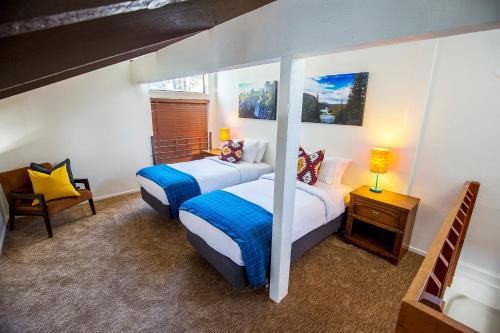 a bedroom with two beds and a chair at The Mammoth House in Mammoth Lakes