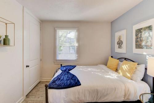 a bedroom with a bed with a blue blanket on it at Walk to the Best of Midtown Charming Cottage in Memphis